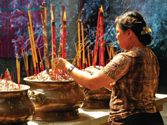 Asia River Cruise - Woman with incense in Ho Chi Minh City